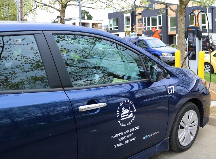 Blue electric car parked by a charging station at City Hall