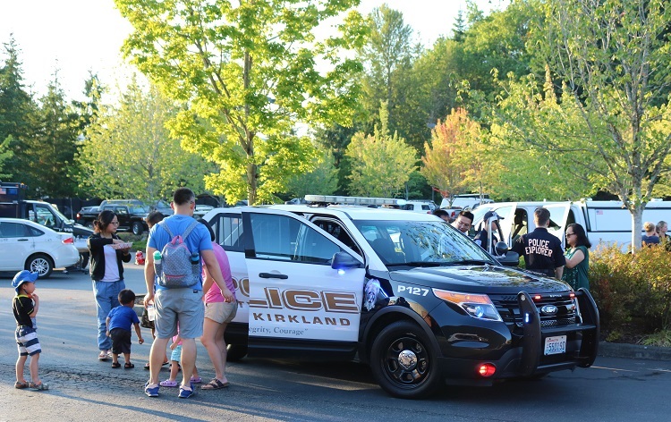 Group of people standing around a police car at National Night Out