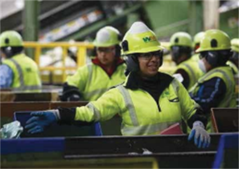 Cascadia Recycling Center employee sorting recycling on conveyor belt  