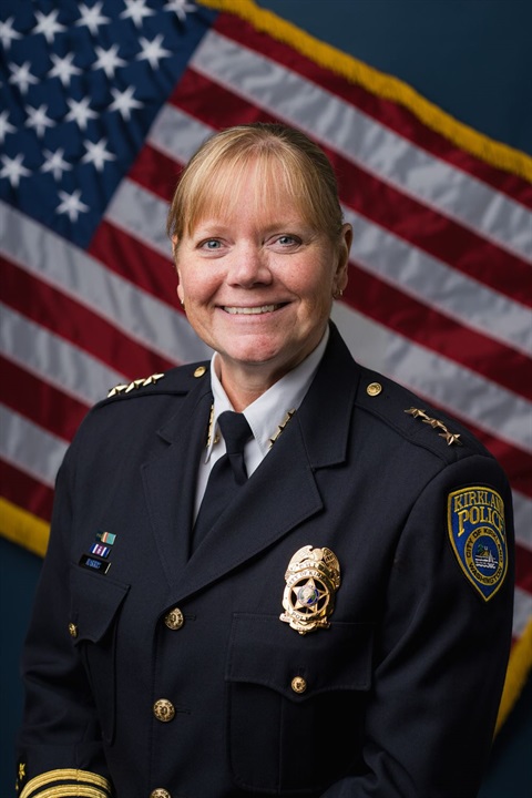 Chief Harris in uniform with flag backdrop
