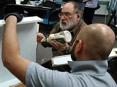 two men gluing back together broken drawer at Repair Cafe at LW Tech