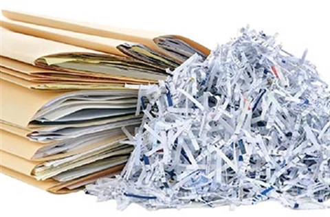 shredded paper with stack of file folders containing paper