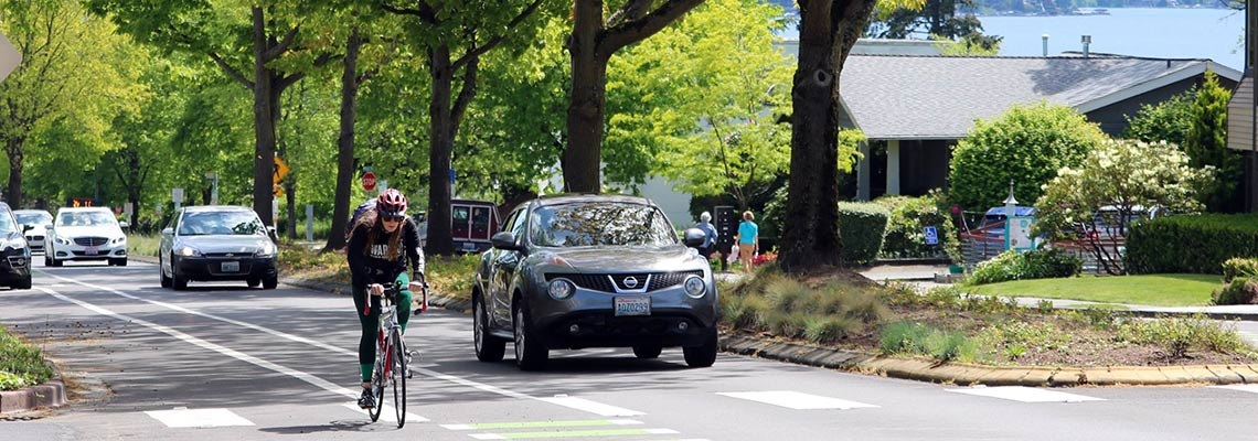 female cyclist riding up Market Street near a striped bike lane