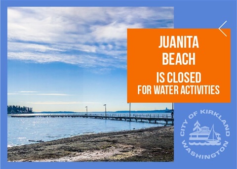 Beach closed sign with Juanita Beach in the background